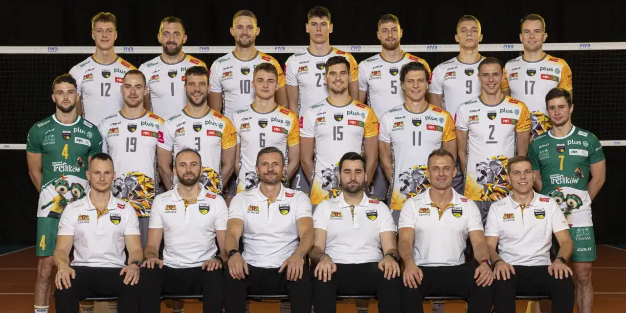 Cała drużyna Trefl Gdańsk w komplecie. Zawodnicy pozują do wspólnego zdjęcia przed siatką.